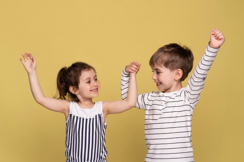Niños felices celebrando con los brazos en alto